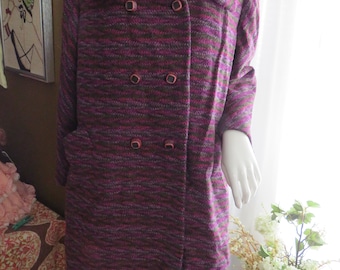 May include: A long, double-breasted coat with a wide collar. The coat is made of a textured fabric in shades of purple, green, and pink. It has four large buttons down the front.