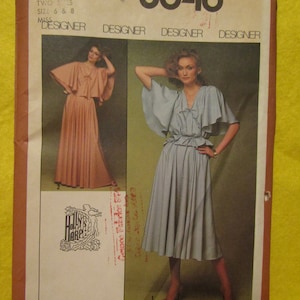 May include: Simplicity sewing pattern number 8646 for a dress with two different styles. The pattern is for sizes 6 and 8. The dress on the left is peach in colour with a long skirt and a ruffled top. The dress on the right is light blue in colour with a shorter skirt and a ruffled top. The pattern is designed by Holly's Harp Inc.