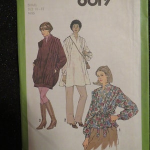 May include: Simplicity sewing pattern number 8619 for misses sizes 10-12. The pattern includes three different styles of tops: a brown tunic with a gathered neckline, a white tunic with a gathered neckline and a floral print blouse with a tie waist.
