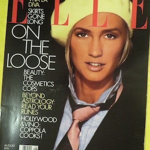 K&ouml;nnte beinhalten: Ein Magazincover mit einer Frau, die einen gelben Barett und einen schwarzen Anzug mit einer rosafarbenen Krawatte tr&auml;gt. Das Magazin hei&szlig;t "ELLE" und der Covertext lautet: "Italien-Spezial: Viva La Diva, R&ouml;cke sind out, Auf der Flucht, Sch&ouml;nheit: Die Kosmetik-Polizisten, Jenseits der Astrologie: Lies deine Runen, Hollywood & Vino: Coppola kocht!" Das Magazin ist datiert auf August 1991.