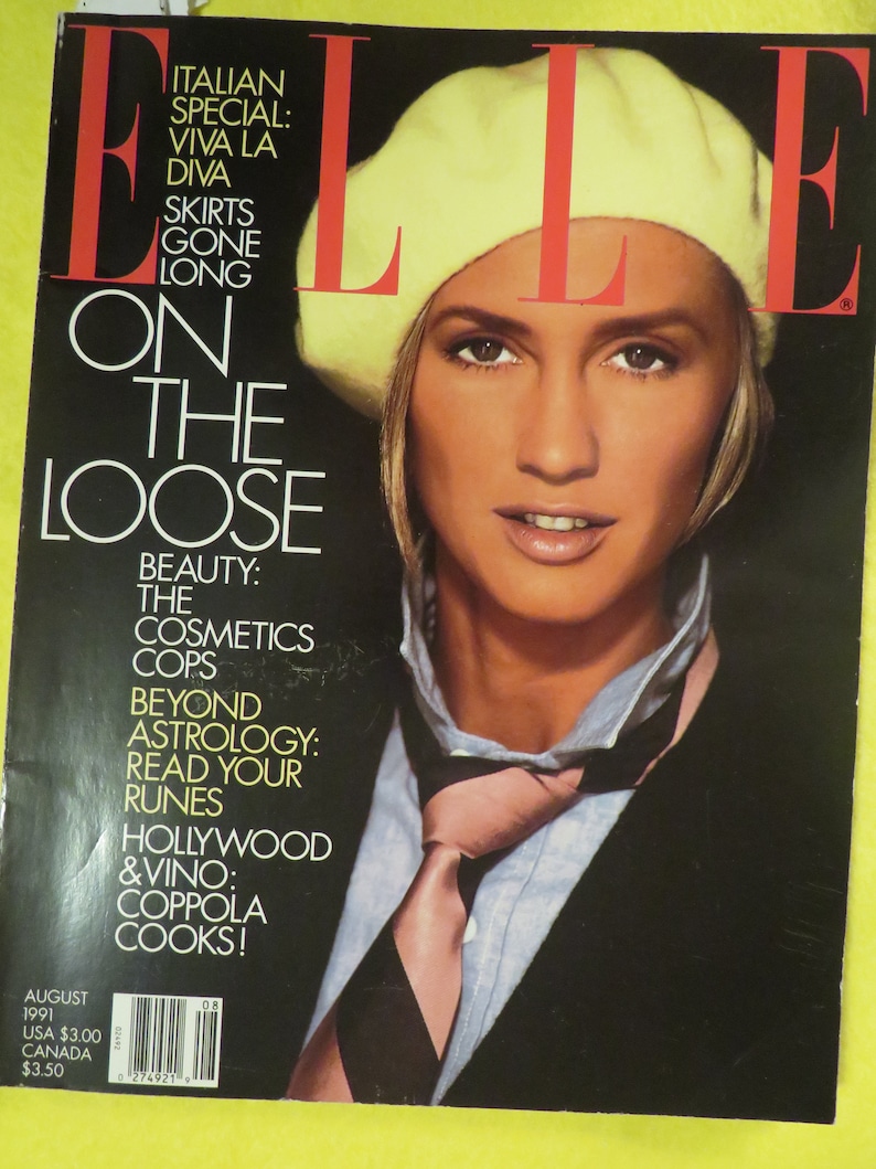 K&ouml;nnte beinhalten: Ein Magazincover mit einer Frau, die einen gelben Barett und einen schwarzen Anzug mit einer rosafarbenen Krawatte tr&auml;gt. Das Magazin hei&szlig;t "ELLE" und der Covertext lautet: "Italien-Spezial: Viva La Diva, R&ouml;cke sind out, Auf der Flucht, Sch&ouml;nheit: Die Kosmetik-Polizisten, Jenseits der Astrologie: Lies deine Runen, Hollywood & Vino: Coppola kocht!" Das Magazin ist datiert auf August 1991.
