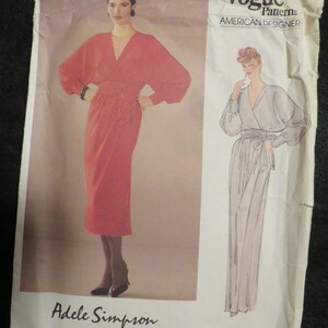 Op de afbeelding: Vogue Patterns American Designer naaipatroon van Adele Simpson, patroonnummer 1169. Het patroon toont twee vrouwen die een lange wikkeljurk met een ceintuur dragen.