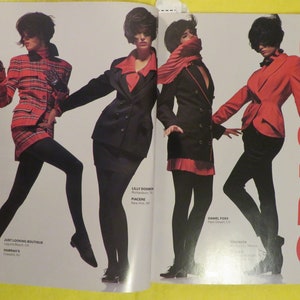 K&ouml;nnte beinhalten: Drei Frauen tragen verschiedene Jacken- und Rockmodelle. Die Frau links tr&auml;gt eine rot-schwarze karierte Jacke und einen Rock. Die Frau in der Mitte tr&auml;gt einen schwarzen Blazer und einen roten Rock. Die Frau rechts tr&auml;gt einen roten Blazer und eine schwarze Hose. Der Text "CRISCA" ist im Hintergrund sichtbar.