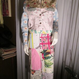 Puede incluir: Una chaqueta vaquera de patchwork con detalles de tela floral y estampada. La chaqueta tiene una base rosa con un estampado floral azul claro y blanco en las mangas. La chaqueta se combina con una falda de patchwork con una variedad de estampados florales y geométricos.