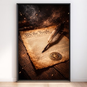 Könnte beinhalten: Gerahmter Druck mit einem Pergamentdokument mit dem Text "We the People". Eine Feder liegt auf dem Dokument, neben einem goldenen Siegel. Das Bild hat eine Vintage-Ästhetik mit dunklem Hintergrund und warmer Beleuchtung.