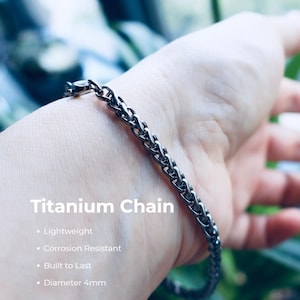 May include: A dark gray titanium chain bracelet with a woven link design. The text on the image reads: Titanium Chain, Lightweight, Corrosion Resistant, Built to Last, Diameter 4mm. The chain features a metallic finish and a secure clasp.