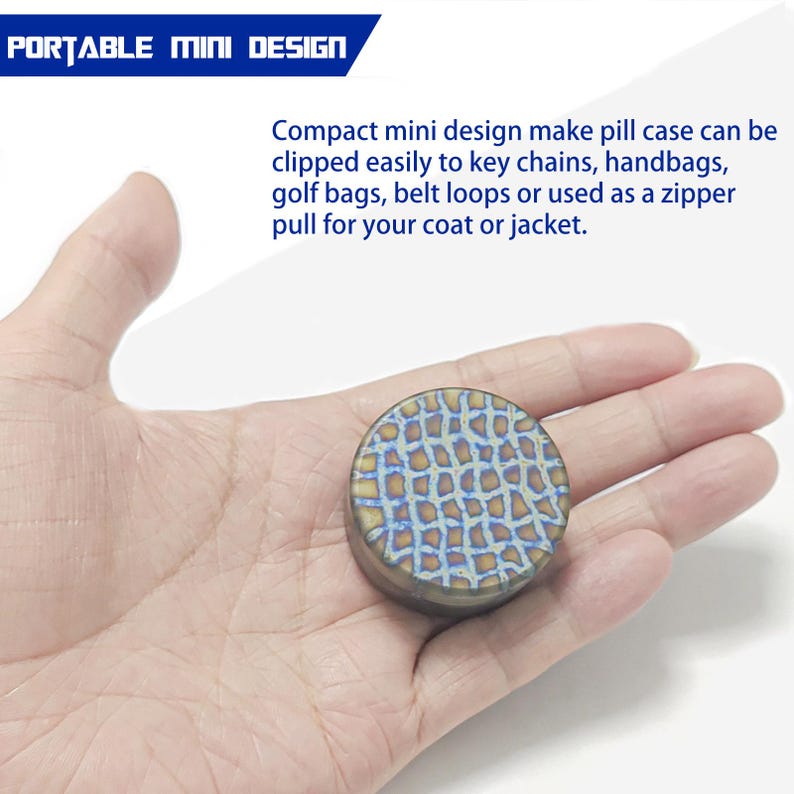 May include: A small, round pill case with a textured, mosaic-like pattern in shades of blue, gold, and bronze. The text "PORTABLE MINI DESIGN" is at the top. The case is designed to be clipped to keychains, handbags, or used as a zipper pull.