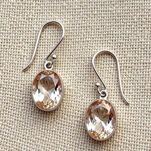 Oval peach crystal earrings with sterling silver hooks, soft pastel gemstone jewelry designed for bridal wear, romantic occasions, office style and everyday elegant fashion accessories.