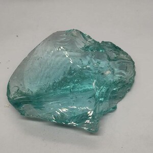 Aqua Andara obsidian crystal rough gemstone with ocean blue glow and rugged edges, ideal for chakra balancing and spiritual altar decor.