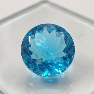 Fine quality Swiss Blue Topaz round cut gemstone displayed as loose precious stone for custom engagement ring and luxury handmade jewelry designs.