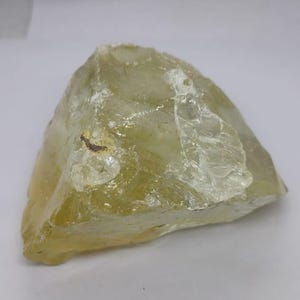 Raw lemon quartz crystal gemstone showing translucent yellow body and rugged edges, perfect for chakra balancing and crystal collection shelves.