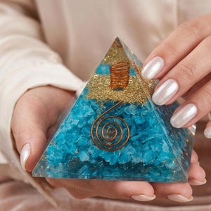 Amazonite crystal pyramid with embedded copper coil spiral designed for chakra healing, Reiki sessions, and spiritual decor accents.