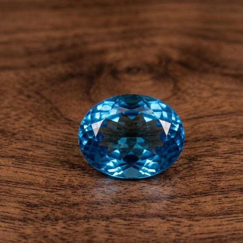 Oval cut blue topaz gemstone with vibrant Swiss blue color and polished finish, perfect for engagement rings and December birthstone jewelry.