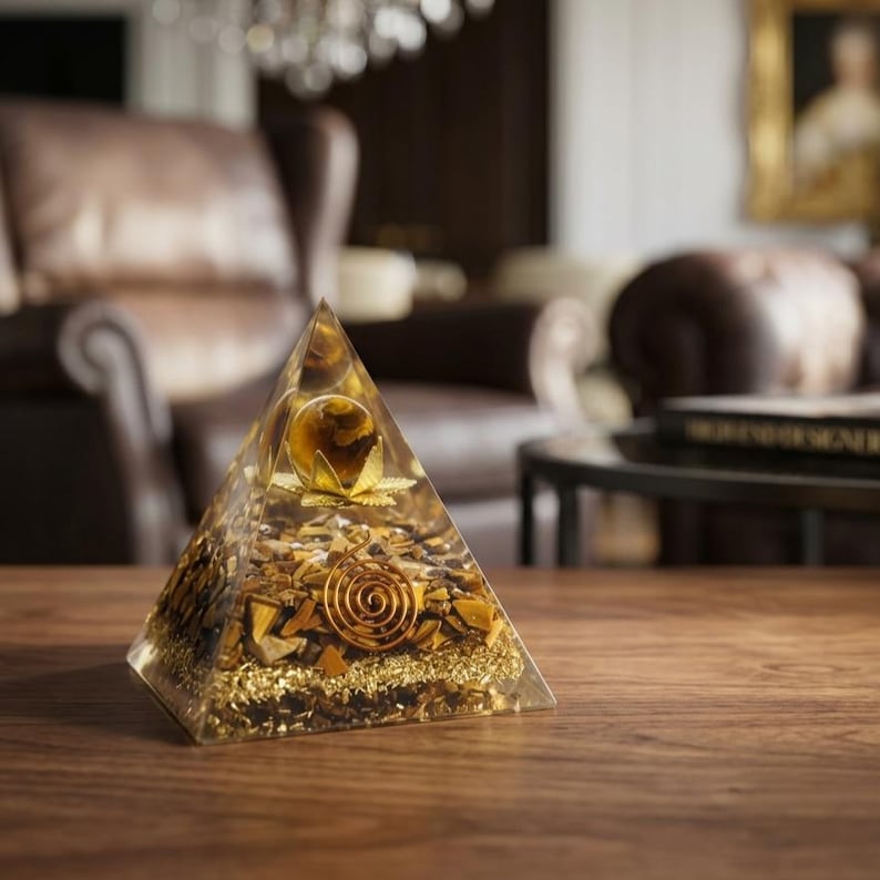 Hand-polished tiger eye gemstone pyramid energy generator placed on marble surface, ideal for manifestation, grounding, and confidence building practices.