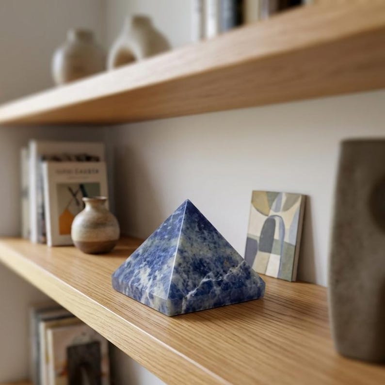 Polished sodalite healing pyramid featuring deep blue and white patterns, ideal for chakra balancing, spiritual home decor and crystal grid centerpiece.