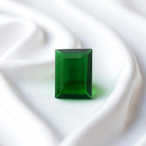 High quality green emerald rectangle cut gemstone with step cut facets and natural inclusions, perfect for jewelry designers, May birthstone gift and collector grade precious gem collections.