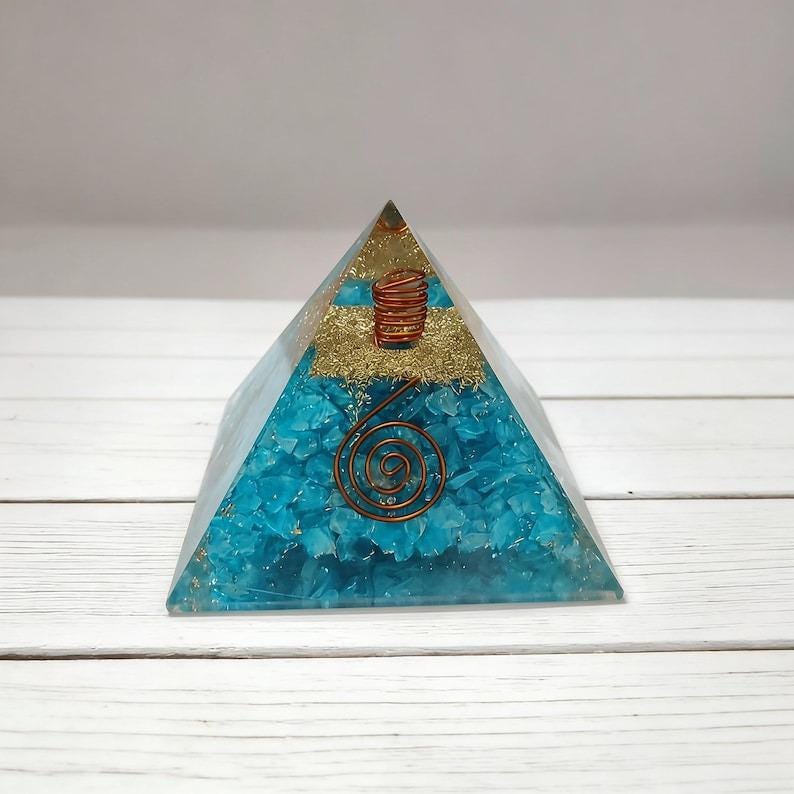 Close-up of amazonite orgonite pyramid showcasing natural crystal chips and copper spiral, popular for EMF protection and spiritual energy balancing.