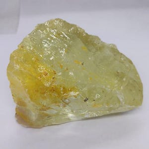 Natural lemon quartz rough crystal stone with organic shape and translucent yellow glow, perfect for spiritual altar decor and gemstone crafting projects.