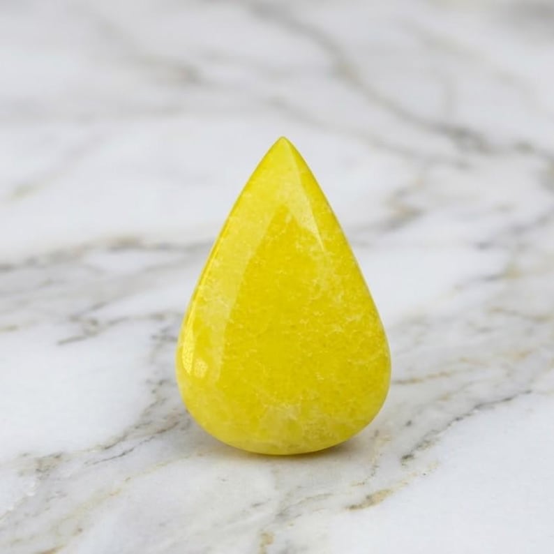 Natural yellow sapphire pear gemstone with vibrant golden yellow color and polished teardrop shape, ideal for engagement rings, custom jewelry making and September birthstone gifts.