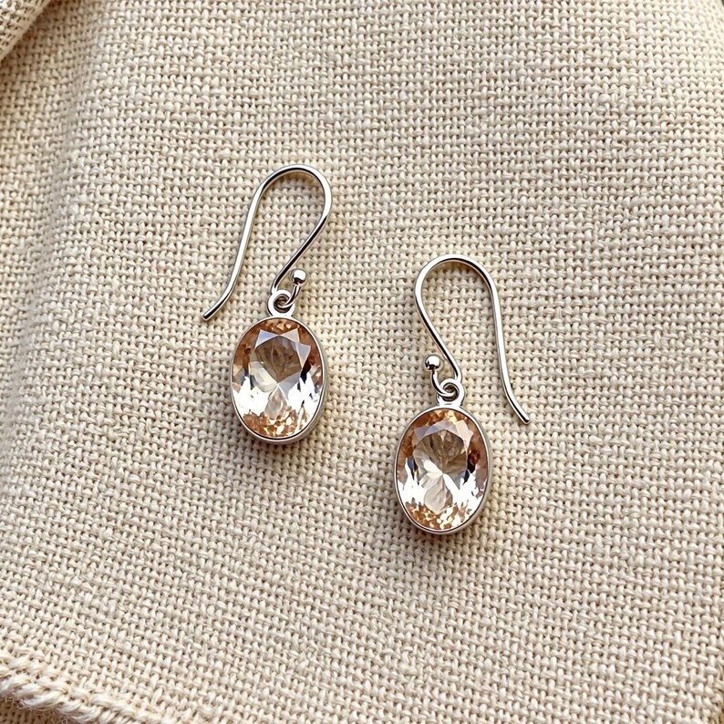 Oval peach crystal earrings with sterling silver hooks, soft pastel gemstone jewelry designed for bridal wear, romantic occasions, office style and everyday elegant fashion accessories.