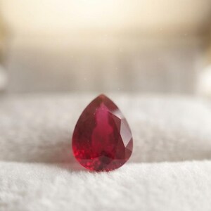 High quality pear cut red ruby gemstone with symmetrical faceting and vivid red hue, perfect for fine jewelry designers and collectors