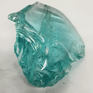 Natural aqua Andara obsidian rough crystal featuring luminous blue green color and smooth reflective surface, perfect for spiritual protection and mineral specimen display.