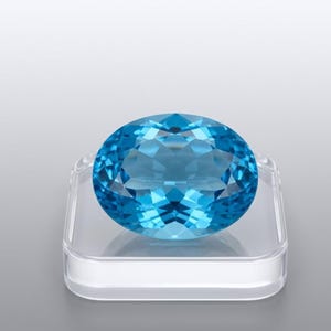 Luxury natural Swiss Blue Topaz oval cut stone with vivid bright blue color, loose precious gem for handcrafted jewelry and gemstone collections.