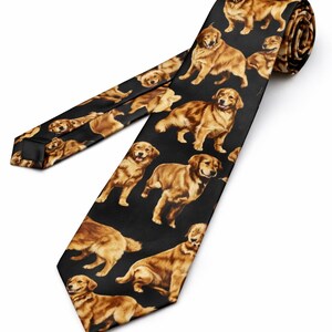 Peut inclure: Une cravate noire ornée d'un motif répété de chiens golden retriever de différentes poses. Les chiens sont représentés dans des tons bruns et fauves sur un fond noir. La cravate est de largeur standard et est enroulée en haut.
