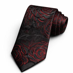 Könnte beinhalten: Gerollte schwarze Krawatte mit einem sich wiederholenden roten Blumenmuster. Die Krawatte besteht aus einem strukturierten Stoff und eignet sich für formelle Anlässe. Das florale Design ist ein herausragendes Merkmal.