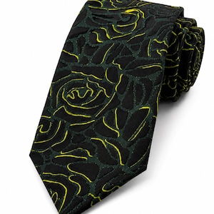 May include: A necktie featuring a dark black and deep green textured floral pattern. The design consists of raised, dark fabric shapes outlined with vibrant neon yellow stitching that forms the contours of rose-like blossoms across the surface.