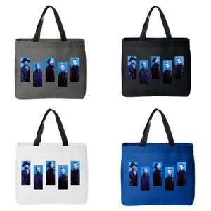 Puede incluir: Cuatro bolsas de mano en diferentes colores: gris, negro, blanco y azul. Cada bolsa presenta un diseño rectangular con un grupo de hombres con trajes negros sobre un fondo azul. Las bolsas tienen asas negras.