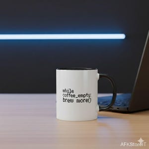 Può includere: Tazza da caffè bianca con interno e manico neri. La tazza presenta il testo "while coffee_empty: brew more()" in nero, con un font pixelato. La tazza è su una superficie di legno, con un laptop sullo sfondo.