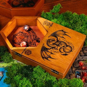 May include: Wooden dice boxes with engraved dragon and skeleton hand designs. The boxes are hexagonal and rectangular, with a natural wood finish. Dice are visible inside the boxes, with a green moss background and a game map.