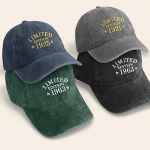 Op de afbeelding: Vier baseballpetten in marineblauw, grijs, donkergroen en zwart. Elke pet heeft de woorden "LIMITED EDITION" en een jaar geborduurd op de voorkant. De jaren zijn 1925, 1921 en 1963. De petten zijn op elkaar gestapeld.