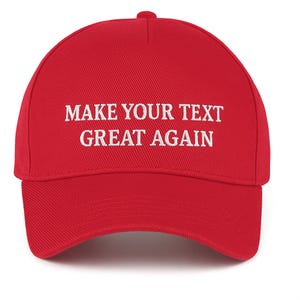 May include: A red baseball cap with a curved brim and a button on top. The cap features white embroidered text that reads "MAKE YOUR TEXT GREAT AGAIN". The hat is made of a textured fabric.