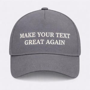 May include: A gray baseball cap with the text "MAKE YOUR TEXT GREAT AGAIN" in white block letters. The cap has a curved brim and a button on top. The hat is made of a durable fabric.