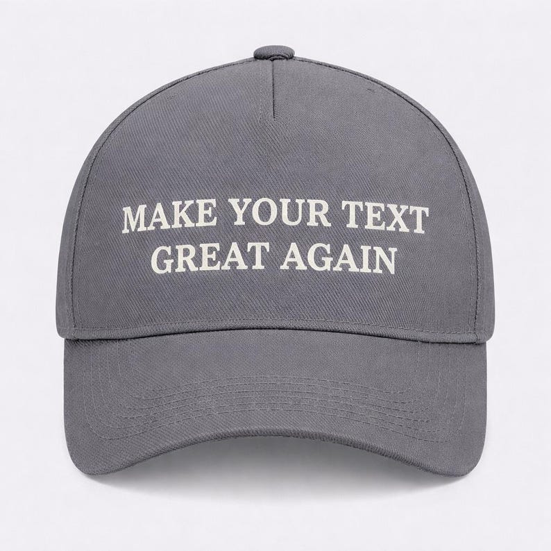 May include: A gray baseball cap with the text "MAKE YOUR TEXT GREAT AGAIN" in white block letters. The cap has a curved brim and a button on top. The hat is made of a durable fabric.