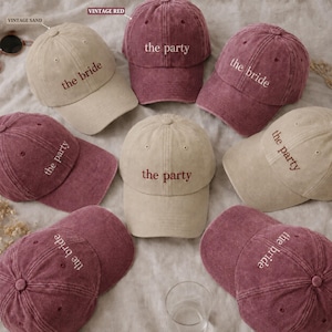 Peut inclure: Un ensemble de six casquettes de baseball dans des tons sable vintage et rouge vintage. Chaque casquette présente un texte brodé sur le devant, certaines indiquant the bride et d'autres the party. Le tissu a un aspect délavé et usé.