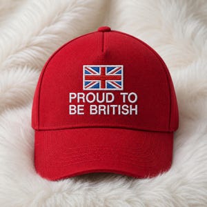 Op de afbeelding: Rode baseballcap met de witte tekst "PROUD TO BE BRITISH". De cap heeft de Union Jack vlag. De pet is gemaakt van stevig materiaal en heeft een gebogen klep.