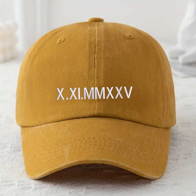 May include: Mustard yellow baseball cap with a curved brim and adjustable strap. The front of the cap features the white text "X.XI.MMXXV". This casual hat is a stylish accessory for everyday wear.