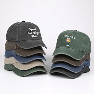 Könnte beinhalten: Zwei Stapel Baseballkappen in verschiedenen gedeckten Farben wie Anthrazit, Braun, Marineblau, Beige und Waldgrün. Die oberste Kappe links zeigt den weißen Text Your Text/Logo Here, während die Kappe rechts eine Cocktail-Grafik aufweist.