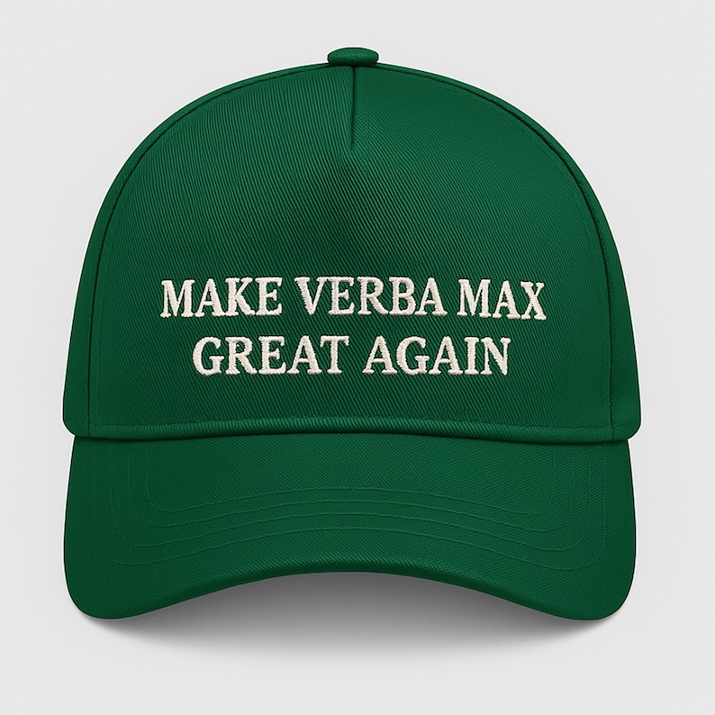 May include: A green baseball cap with the embroidered text "MAKE VERBA MAX GREAT AGAIN" in white. The cap has a curved brim and a button on top.