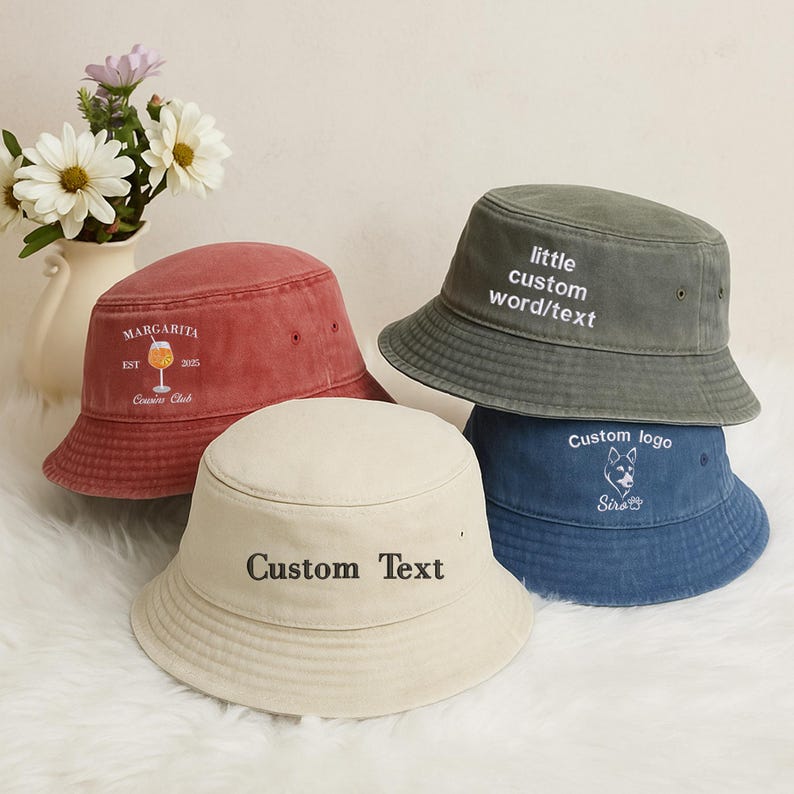 May include: Four bucket hats in various colors: red, cream, olive green, and blue. The red hat has "MARGARITA" and "Cousins Club" text. The cream hat says "Custom Text". The green hat says "little custom word/text". The blue hat has a dog logo.