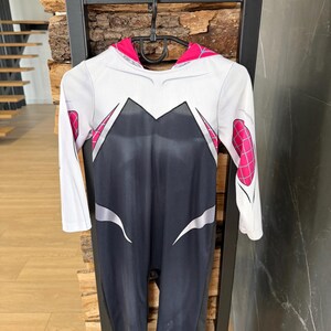 May include: A white ceramic mug with a black handle and the text "But First, Coffee" in a black, handwritten-style font. The mug is on a white surface.