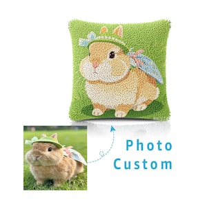 May include: A square throw pillow featuring a textured punch needle design of a tan rabbit wearing a green hat and a blue patterned cape against a bright green background. The text Photo Custom is printed in blue next to a reference photo.