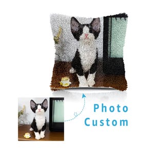 Peut inclure: Un coussin décoratif avec un motif de chat noir et blanc. Le chat est représenté assis avec de grandes oreilles et un nez rose. Le coussin a un aspect texturé, avec une palette de couleurs marron et grise. Les mots "Photo Custom" sont également visibles.