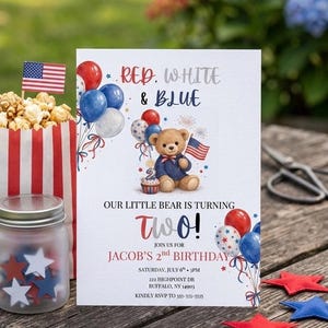 May include: A patriotic birthday invitation with the text "Red, White & Blue" and "Two!" A teddy bear holds a flag and balloons. Includes popcorn, a jar with star cutouts, and red, white, and blue star decorations.