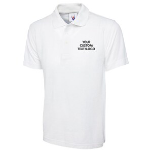May include: A white polo shirt with a collar and short sleeves. The shirt features the text "YOUR CUSTOM TEXT/LOGO" printed in black on the chest. The shirt is made of a soft, breathable fabric.