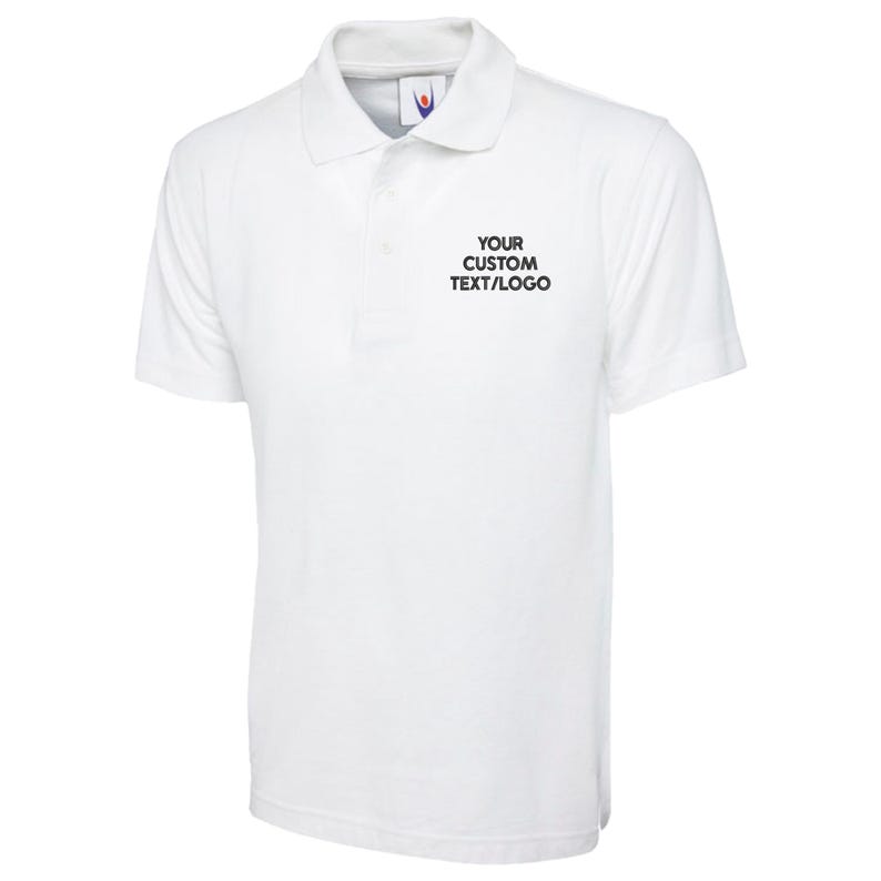 May include: A white polo shirt with a collar and short sleeves. The shirt features the text "YOUR CUSTOM TEXT/LOGO" printed in black on the chest. The shirt is made of a soft, breathable fabric.