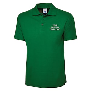 May include: A green polo shirt with short sleeves and a collar. The shirt has a three-button placket and the text "YOUR CUSTOM TEXT/LOGO" printed in white on the chest. The shirt is made of a soft, breathable fabric.